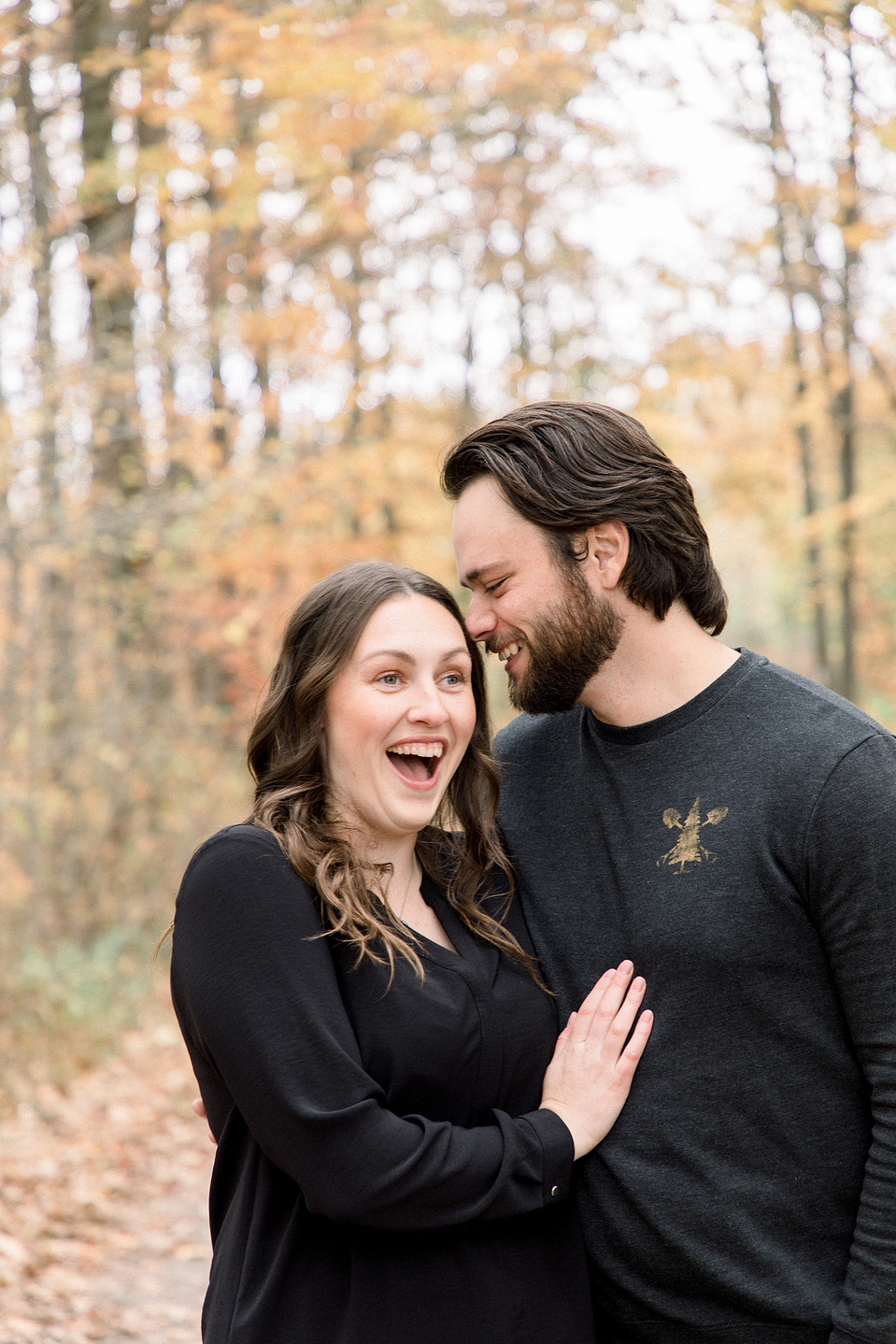Portrait of couple, man whispering secret to woman, woman looks surprised. Niagara portrait photography, Niagara portrait photographer, Niagara family photography, Niagara family photographer.
