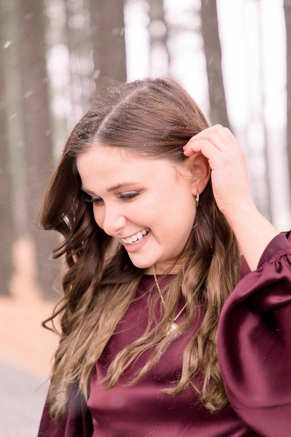 Portrait of a woman playing with her hair and smiling on a winter trail, Niagara family photographer, family photography, Niagara portrait photographer, portrait photography, Champlain photographer, Hawkesbury photographer, Emily VanderBeek Photography.