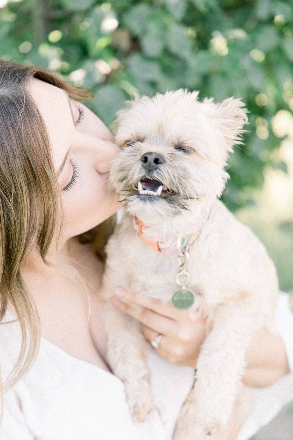 Portrait of woman holding puppy and kissing it on the cheek on a sunny day, Niagara portrait photographer, portrait photography, Niagara family photographer, family photography, pet photography, Emily VanderBeek Photography.