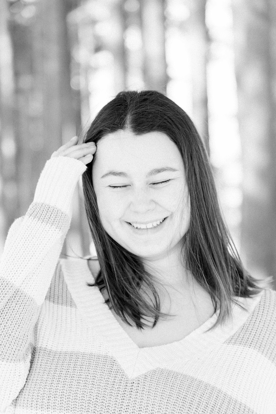 Black and white candid portrait of a young woman playing with her hair, Niagara family photographer, family photography, Niagara portrait photographer, portrait photography, Champlain photographer, Hawkesbury photographer, Emily VanderBeek Photography.