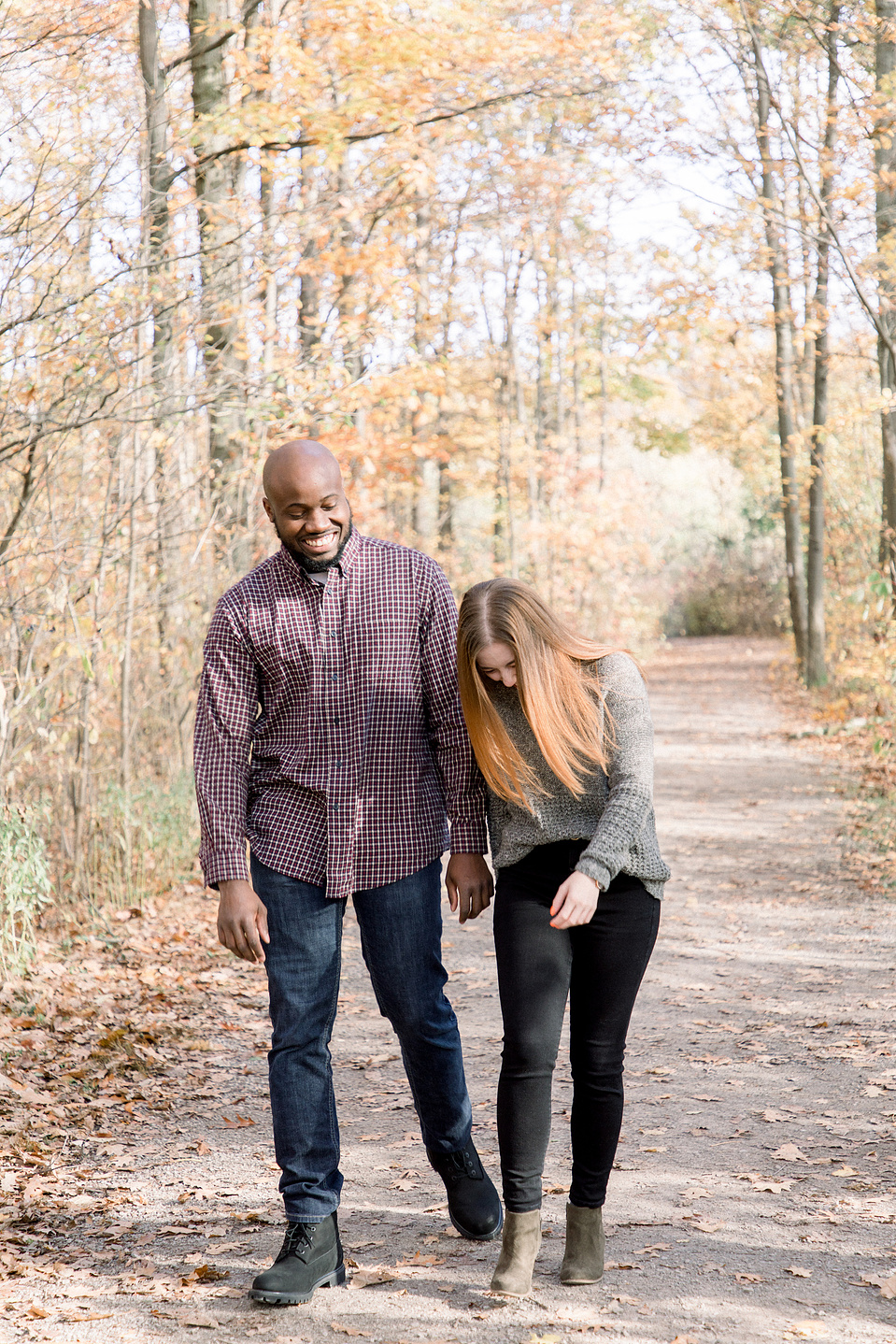 Portrait of couple walking down path, bumping hips and laughing. Niagara portrait photography, Niagara portrait photographer, Niagara family photography, Niagara family photographer.