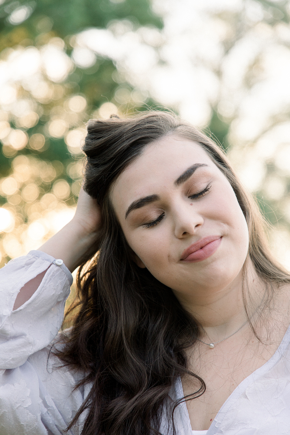 Close-up portrait of woman with her eyes closed and hand in hair. Niagara portrait photography, Niagara portrait photographer, Niagara branding photography, Niagara branding photographer.