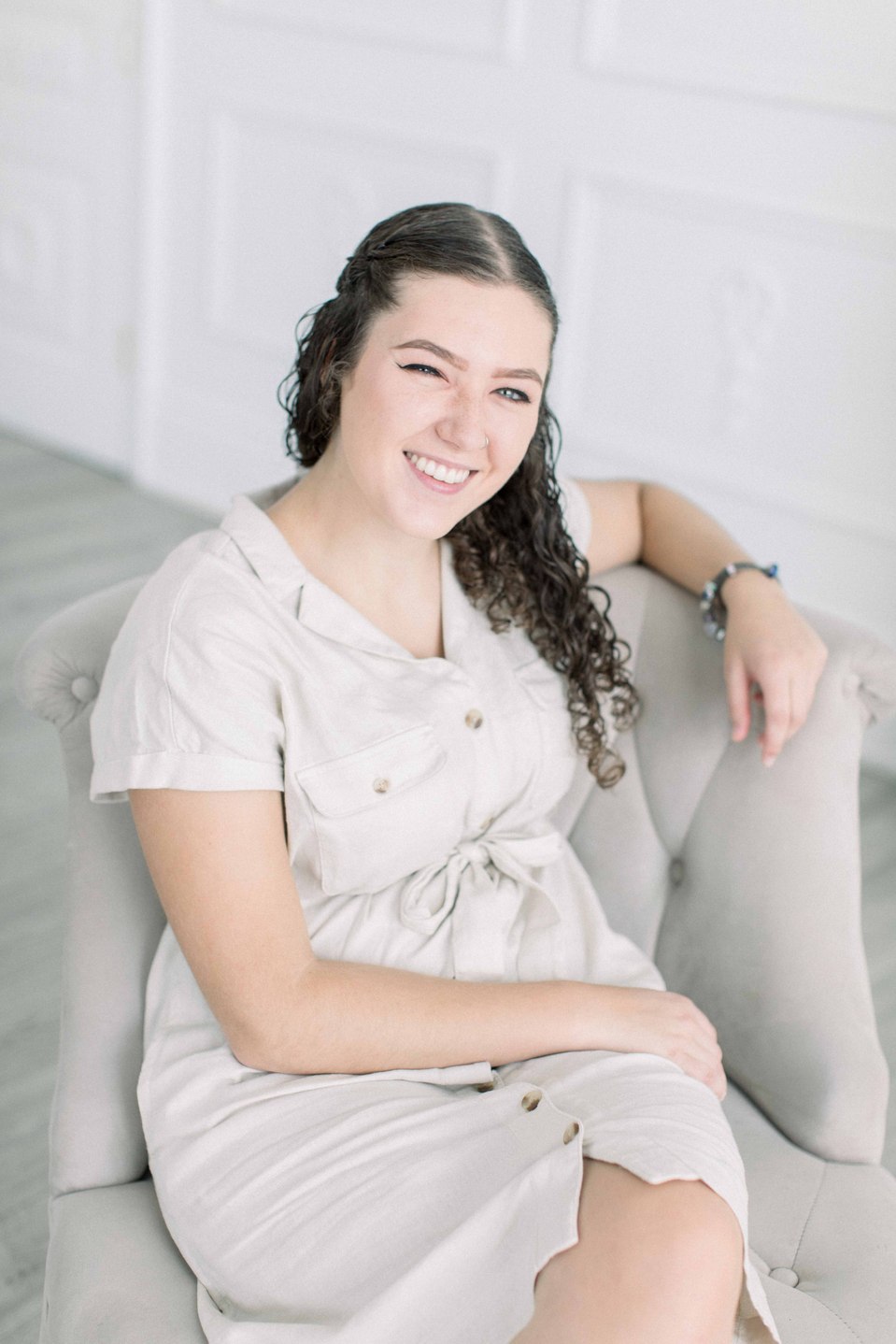 Portrait of woman sitting on chair looking into the camera, smiling. Niagara portrait photography, Niagara portrait photographer, Niagara branding photography, Niagara branding photographer, Niagara family photography, Niagara family photographer.