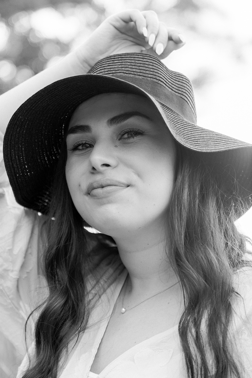 Black and white close-up portrait of woman wearing hat looking into the camera. Niagara portrait photography, Niagara portrait photographer, Niagara branding photography, Niagara branding photographer.