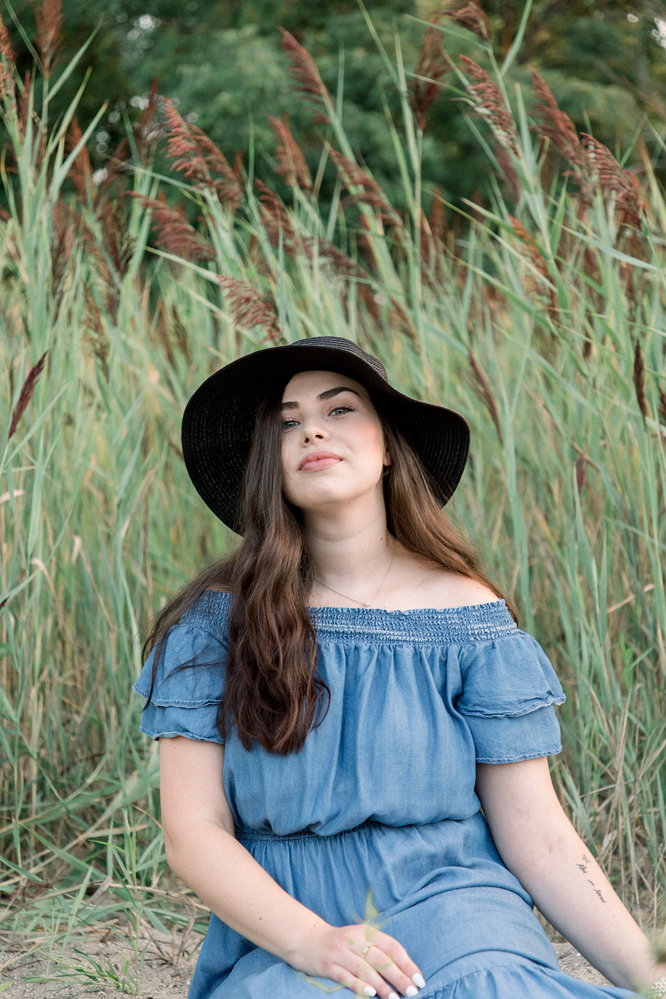 Full portrait of woman looking into the camera while sitting on the beach. Niagara portrait photography, Niagara portrait photographer, Niagara branding photography, Niagara branding photographer.
