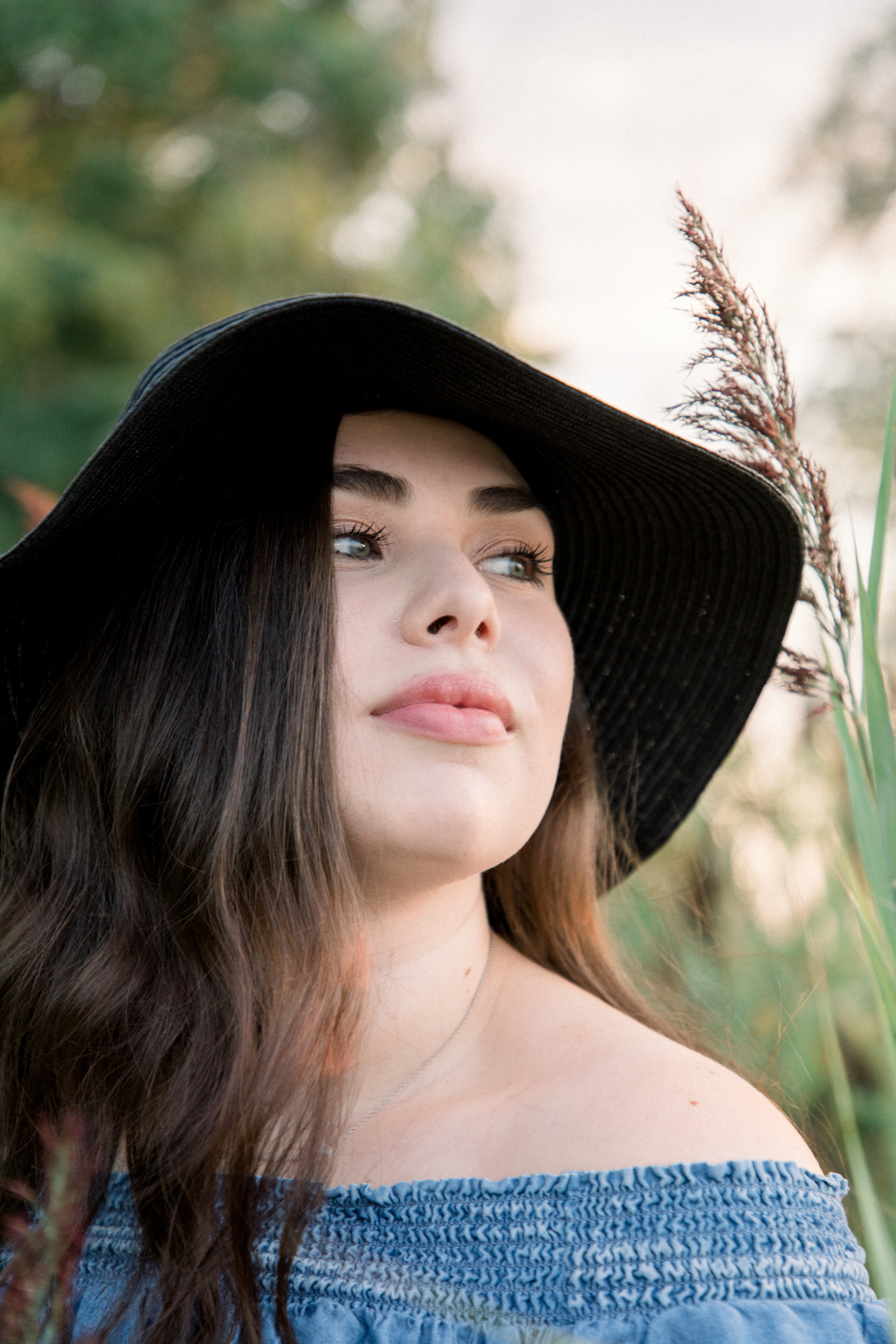Close-up portrait of woman wearing hat looking off into the distance. Niagara portrait photography, Niagara portrait photographer, Niagara branding photography, Niagara branding photographer.