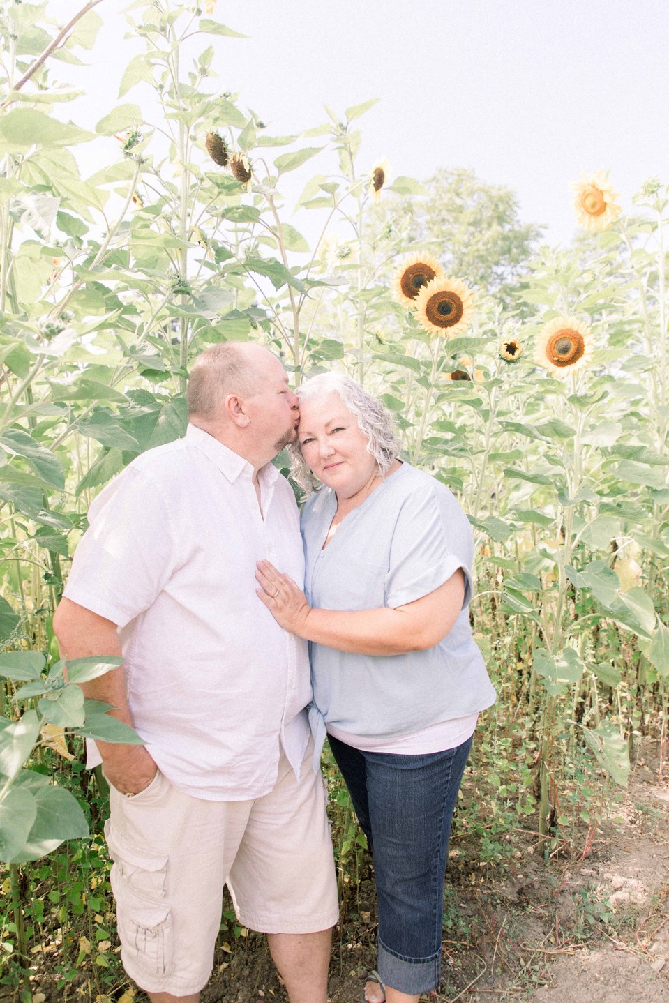 Portrait of couple hugging each other in a sunflower field, Niagara family photographer, family photography, Niagara portrait photographer, portrait photography, Emily VanderBeek Photography.