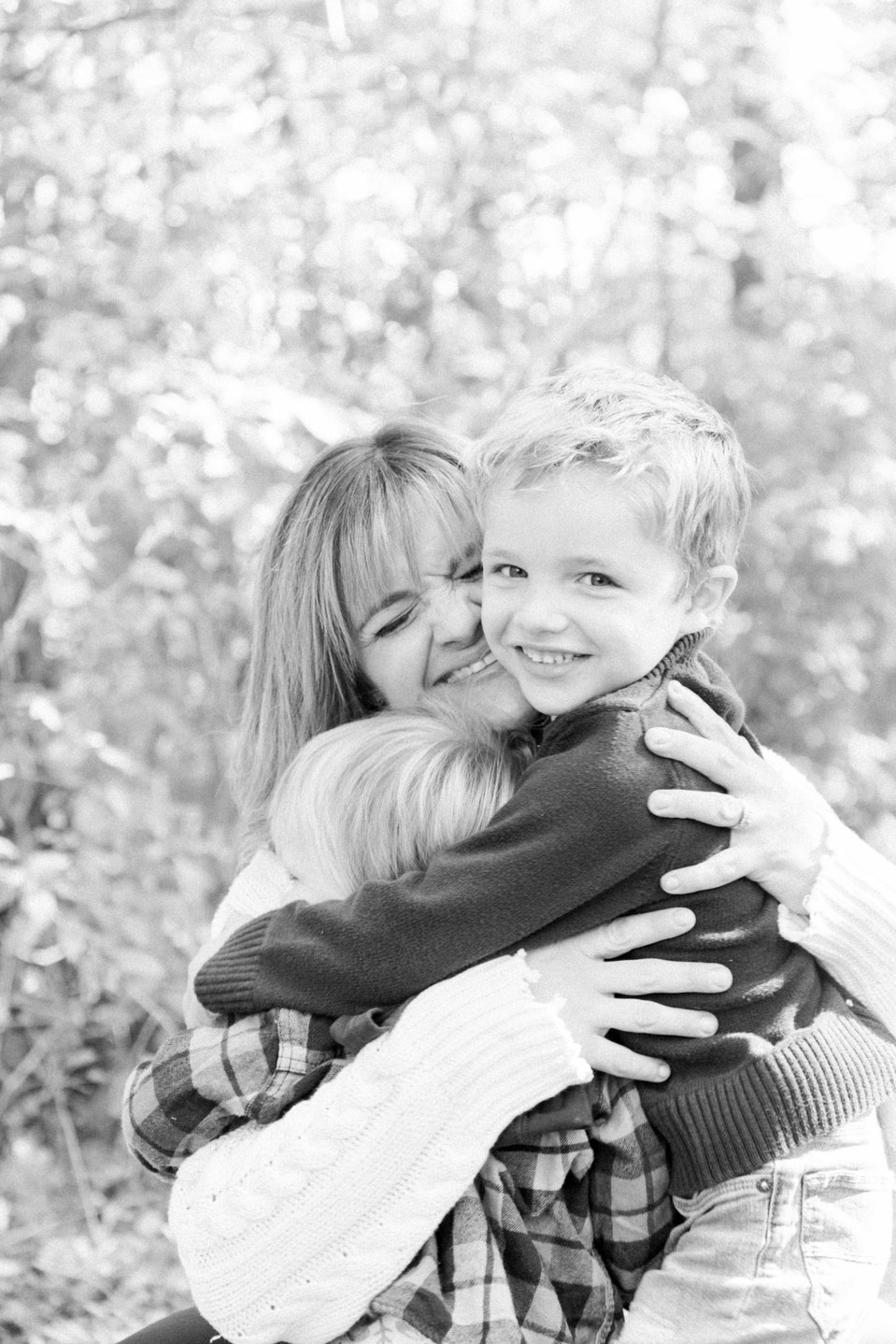 Black and white candid portrait of mother hugging two sons, Fall photos, Niagara family photographer, family photography, Niagara portrait photographer, portrait photography, Emily VanderBeek Photography.