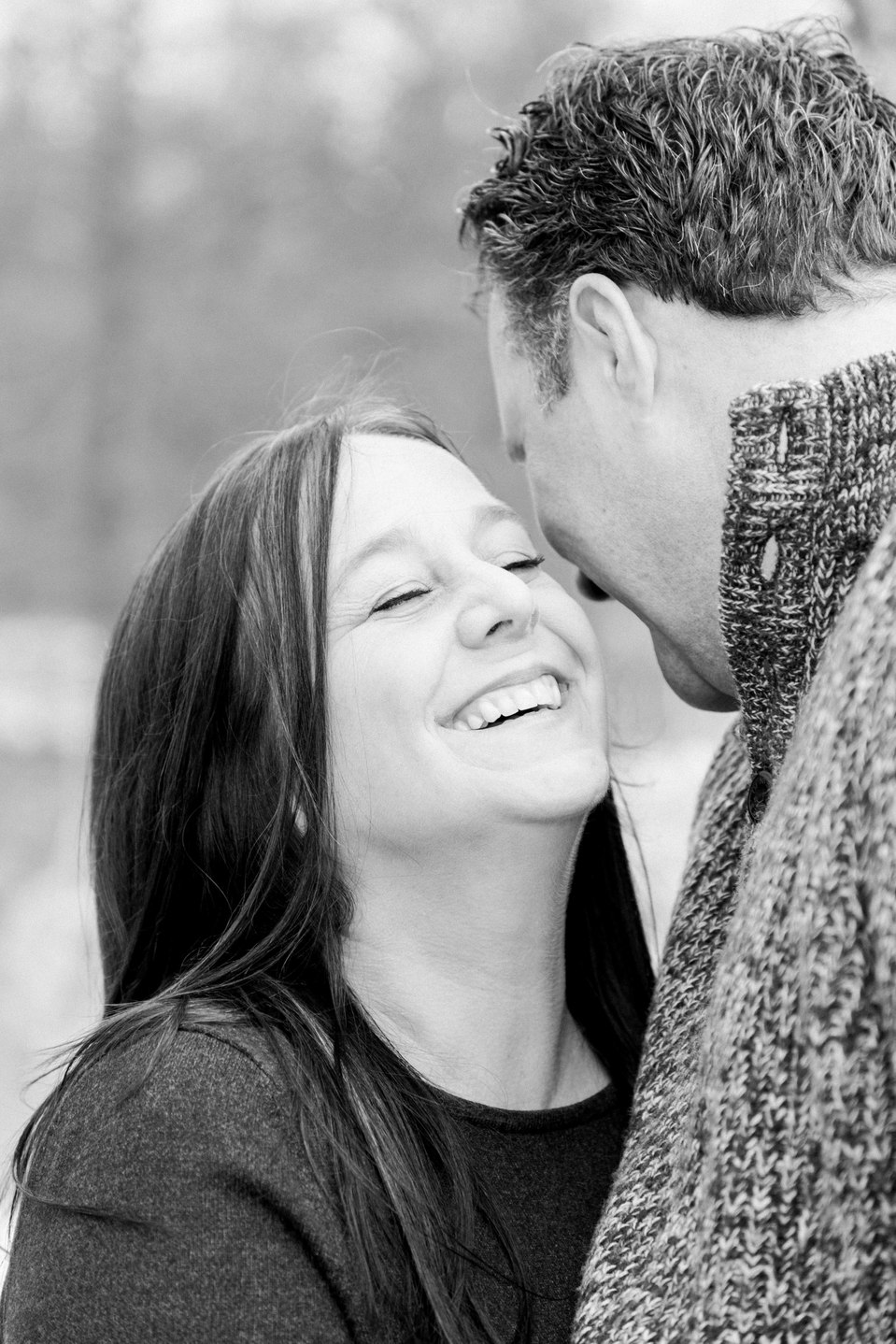 Black and white portrait of husband and wife, husband telling wife a secret to make her laugh, Niagara family photographer, family photography, Niagara portrait photographer, portrait photography, Emily VanderBeek Photography.