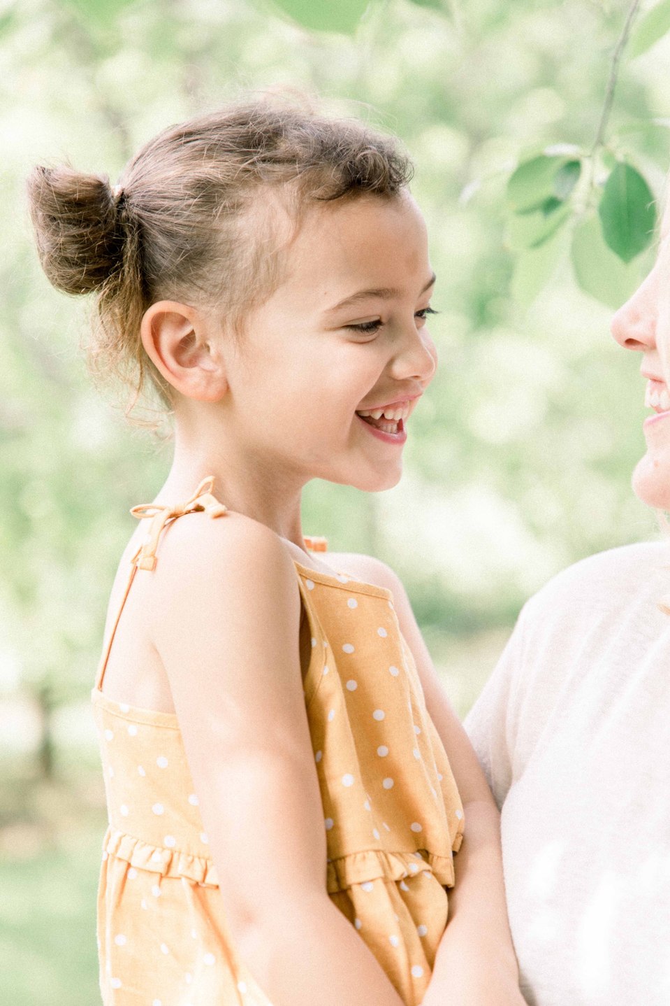 Portrait of little girl smiling and laughing in fruit orchard, Niagara family photographer, Niagara portrait photographer, family photography, portrait photography, candid photography, authentic photography, Emily VanderBeek Photography.