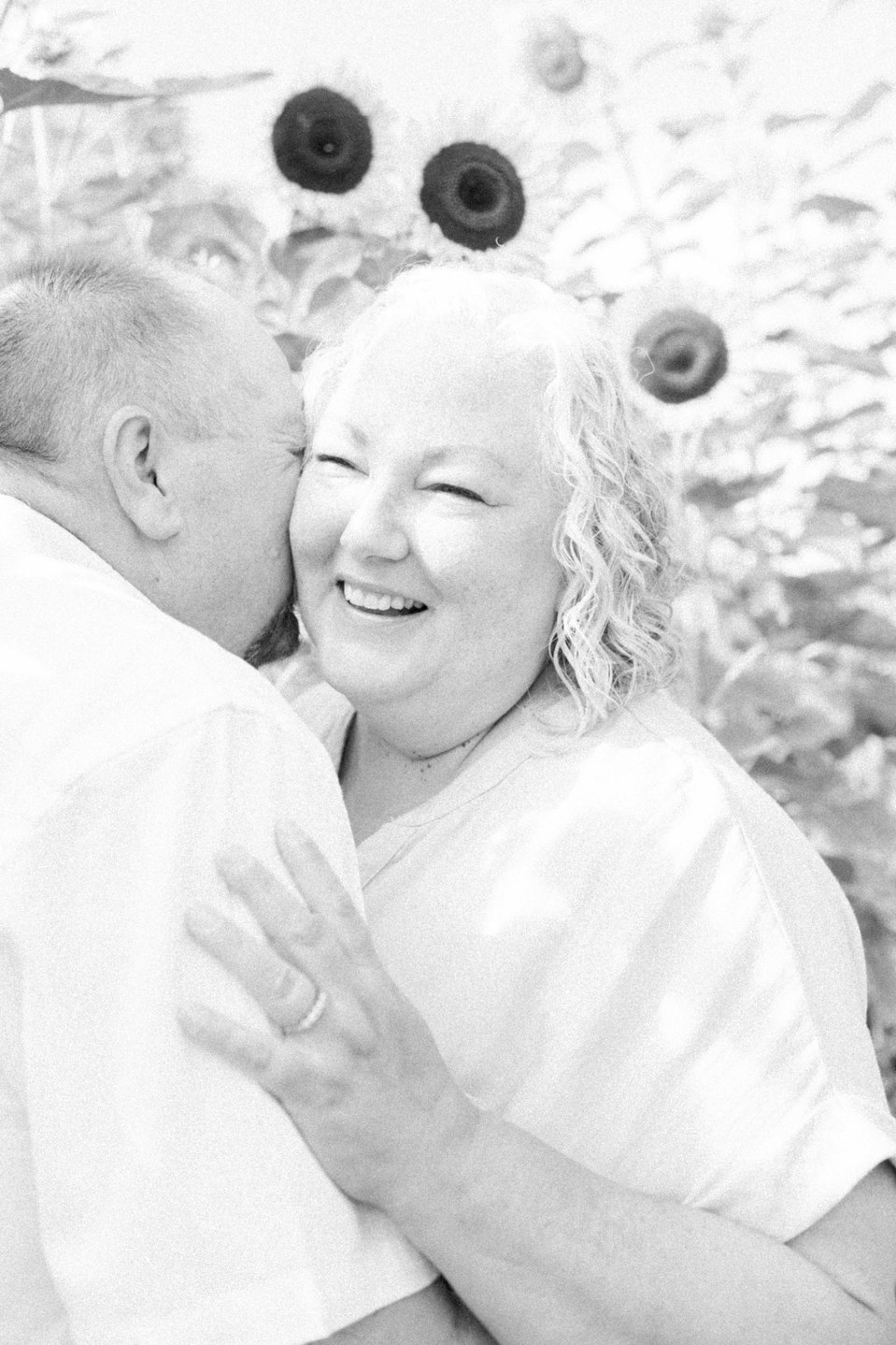 Black and white portrait of couple hugging each other in a sunflower field, Niagara family photographer, family photography, Niagara portrait photographer, portrait photography, Emily VanderBeek Photography.
