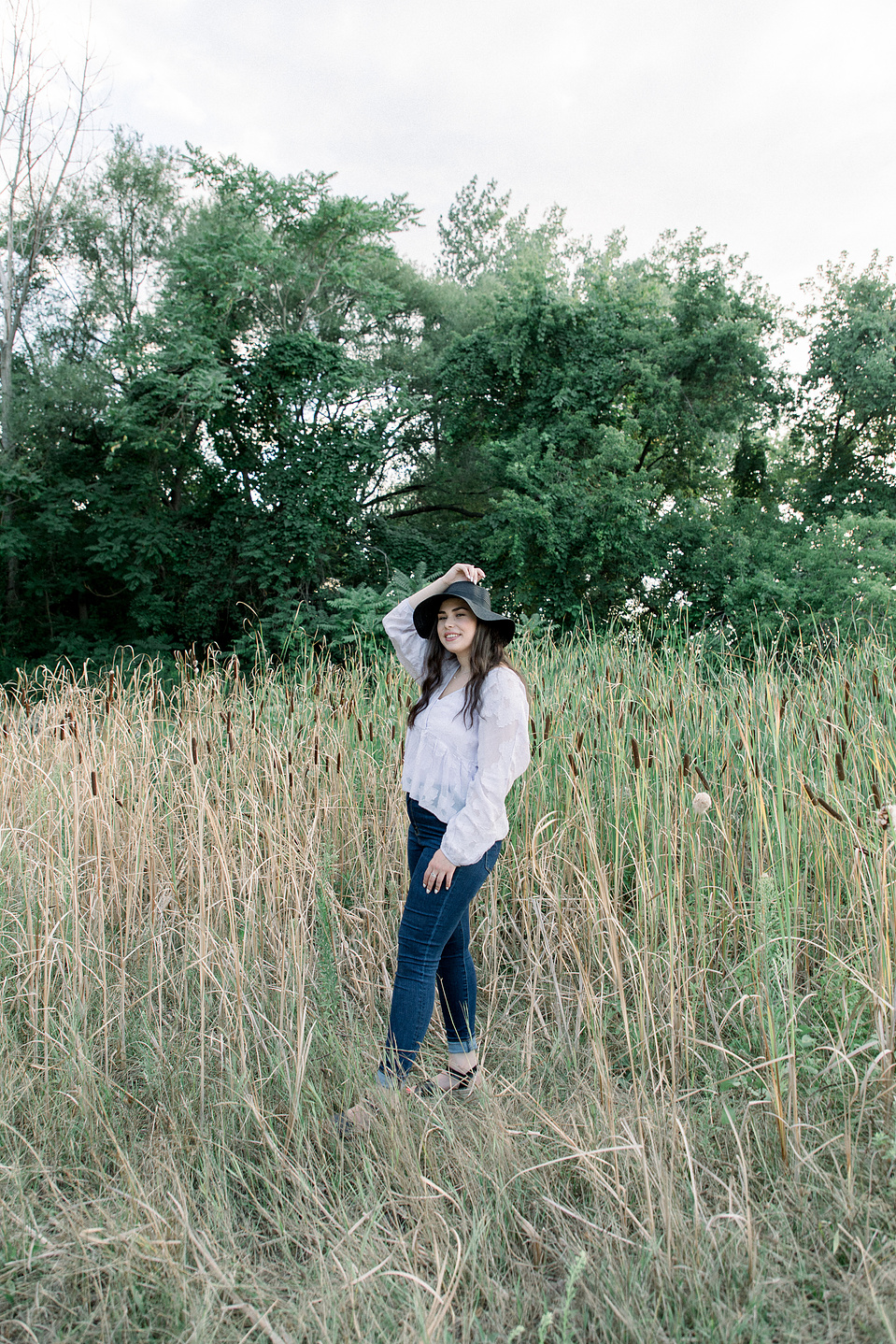 Full length portrait of woman wearing hat amongst tall grass. Niagara portrait photography, Niagara portrait photographer, Niagara branding photography, Niagara branding photographer.