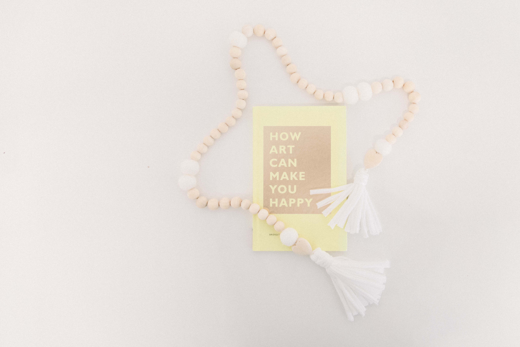 Product photo of handmade wooden garland and book called "How Art Can Make You Happy". Emily VanderBeek Photography, branding photography, portrait photography, Niagara portrait photographer, Niagara branding photographer.