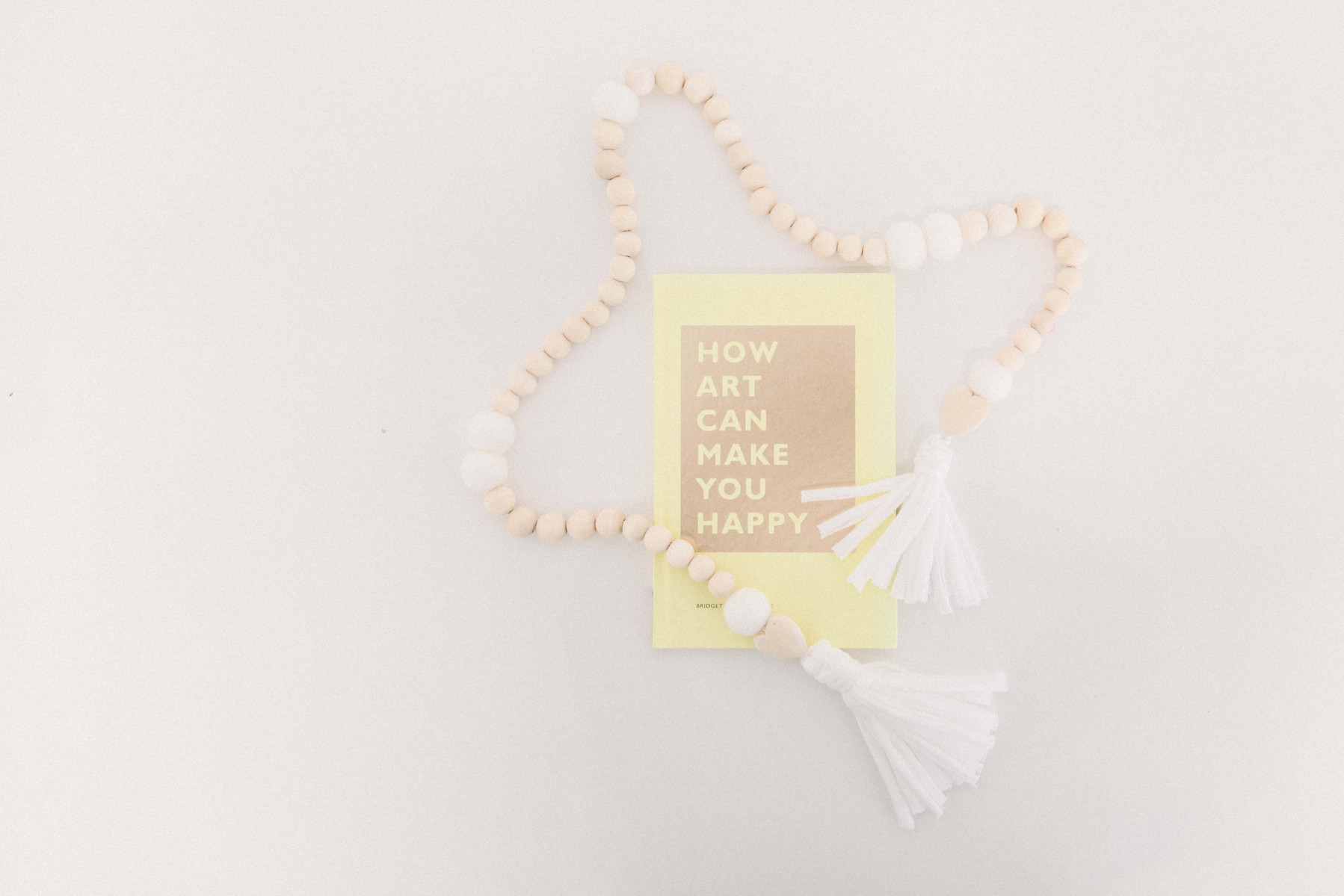 Product photo of handmade wooden garland and book called "How Art Can Make You Happy". Emily VanderBeek Photography, branding photography, portrait photography, Niagara portrait photographer, Niagara branding photographer.