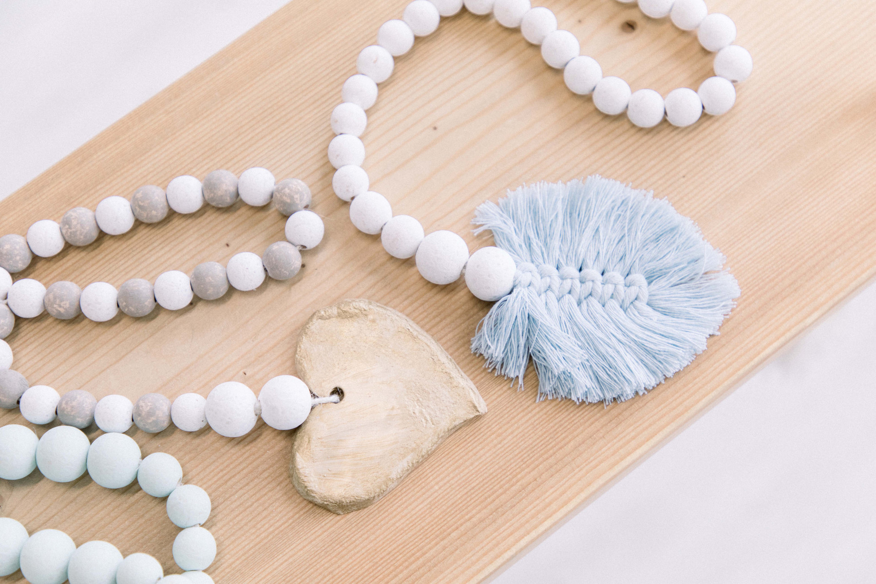 Product photo of two handmade wooden garlands resting on a swing. Emily VanderBeek Photography, branding photography, portrait photography, Niagara portrait photographer, Niagara branding photographer.