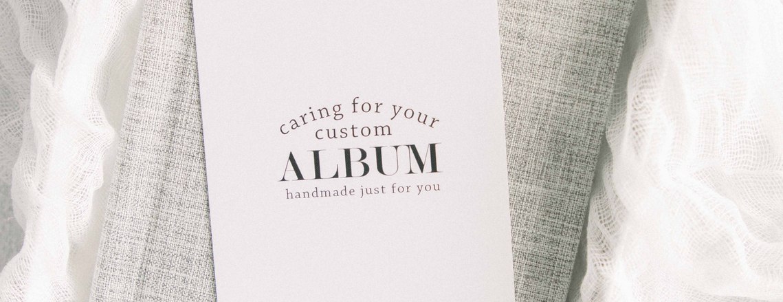 Stylized product photo of grey linen album on textured fabric, Emily VanderBeek Photography, Portrait and Family photography, Niagara Photographer, Champlain Photographer, Vaudreuil-Soulanges Photographer, candid photography, authentic photography.