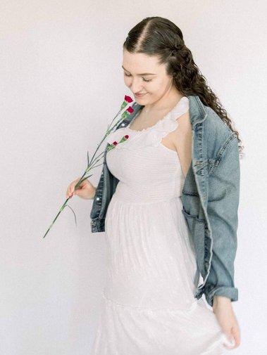 Portrait of woman in white dress and jean jacket smelling flowers, Emily VanderBeek Photography, Portrait and Family photography, Niagara Photographer, Champlain Photographer, Vaudreuil-Soulanges Photographer, candid photography, authentic photography.