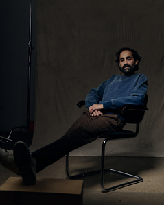 Dark, moody studio portrait of a man sitting in a chair. Photographed at South Facing Windows studio in Chicago, Illinois. 