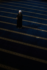environmental portrait of an Imam, islamic religious pastor, in a mosque.