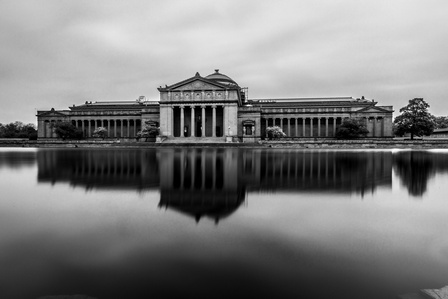 Long exposure of the Science and Industry museum reflected over a pond in Chicago Illinois. Black and white image. 