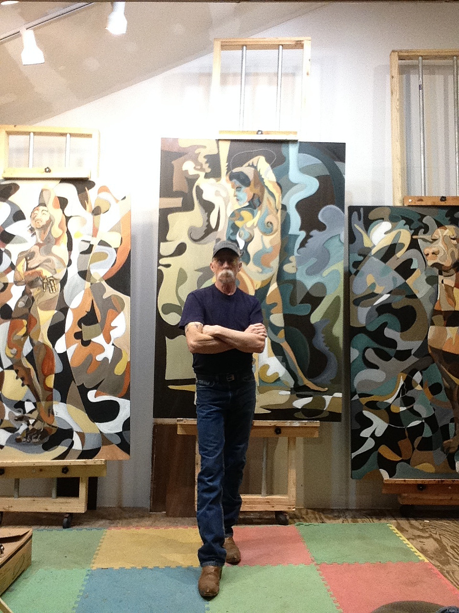 Mark Dyer in his studio, standing in front of his paintings for scale