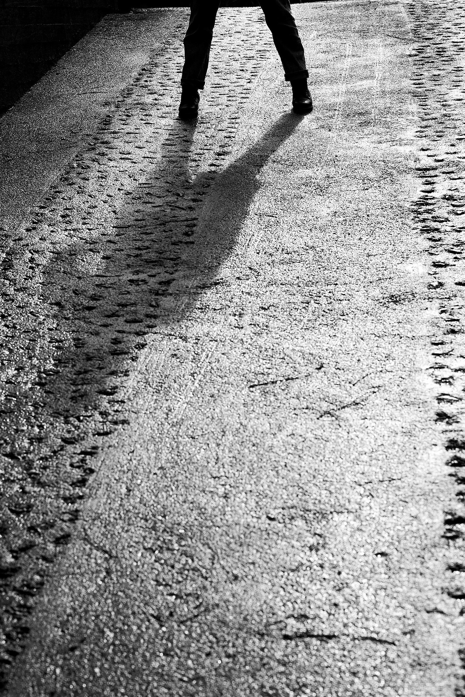 A figure standing on concrete slip casts an imposing shadow on the ground