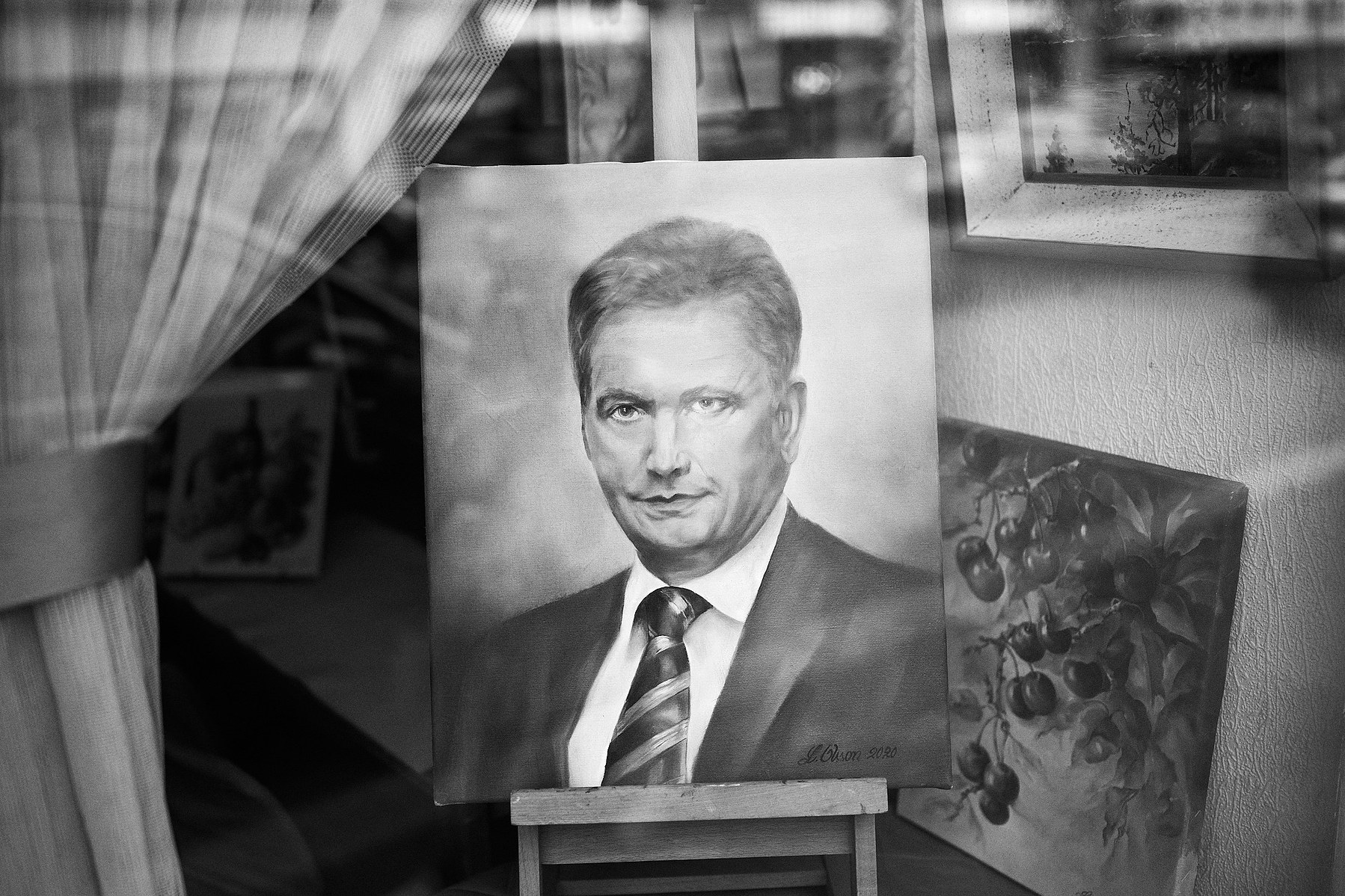 A painted portrait of the Finnish president Sauli Niinistö on behind shop window