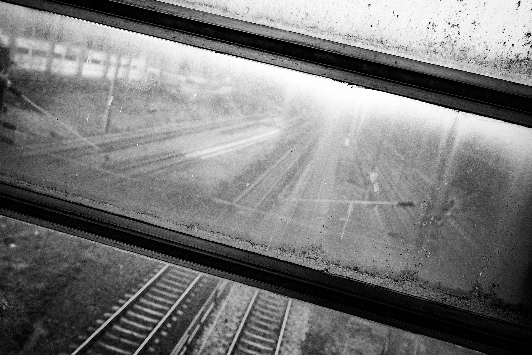 Parallel train tracks seen trough a dirty window