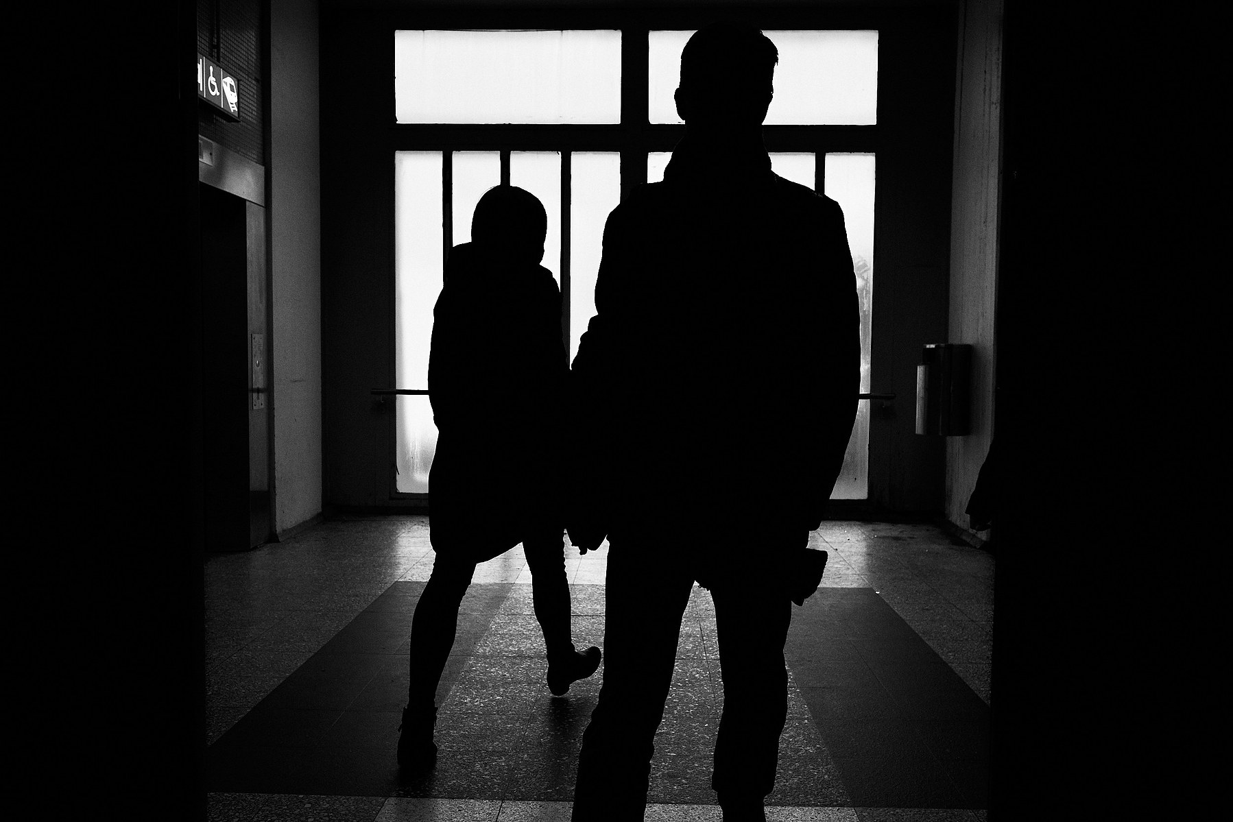 Two people pass each other at Malmi train station during late Friday rush hour