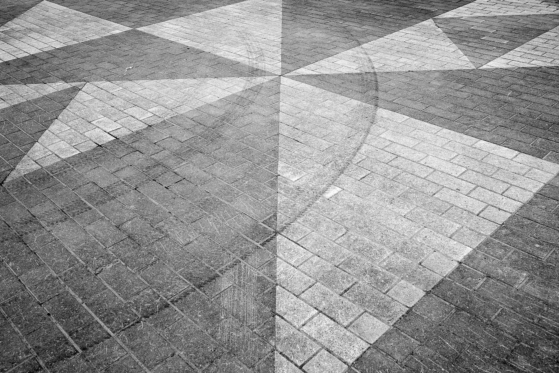 Tyre tracks on geometric triangle formed paving stones