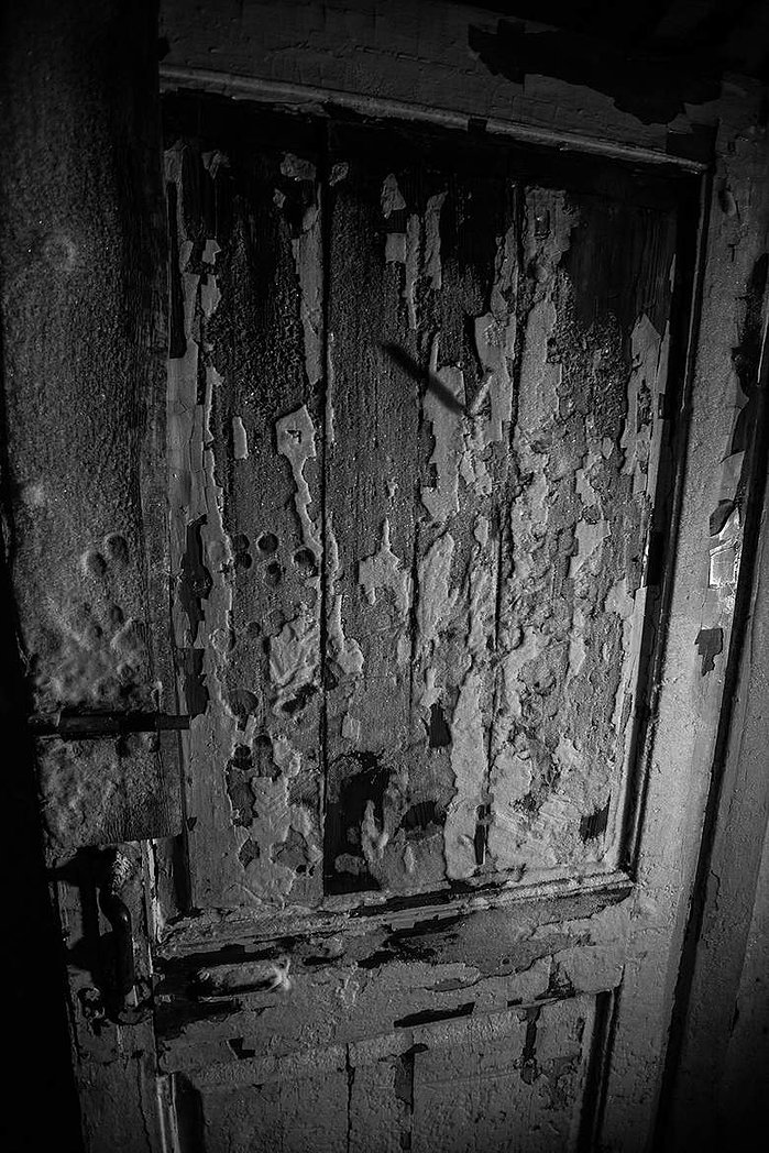 A wooden door covered in ice and frost inside an abandoned building in Moscow.