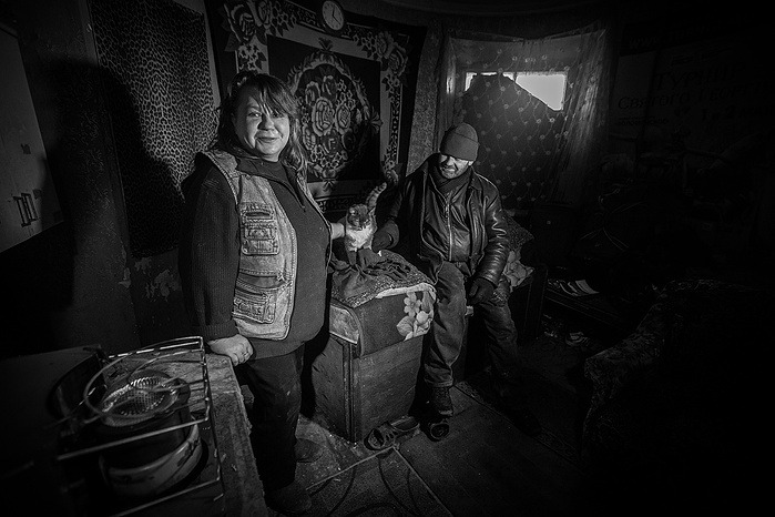A portrait of a man and woman. They are homeless and take shelter in an abandoned building in Moscow.