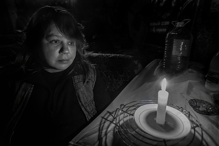 A portrait of a homeless woman in an abandoned building in Moscow. She is lit by a single candle.