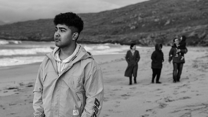 Zakar, an Afghan refugee walks along Luskentyre Beach with his family.