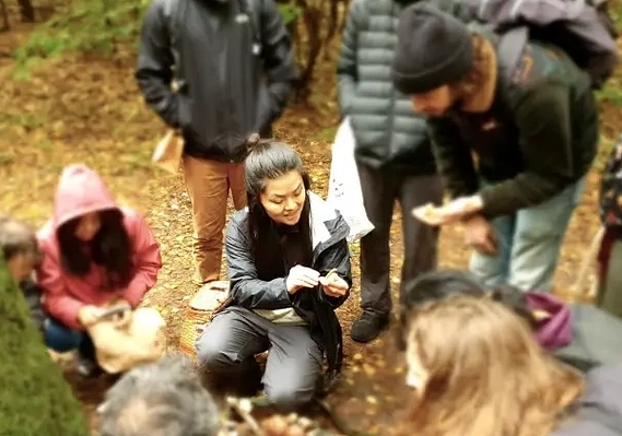 Mushroom Tour in progress, where guide is showing a mushroom and talking about it with participants.