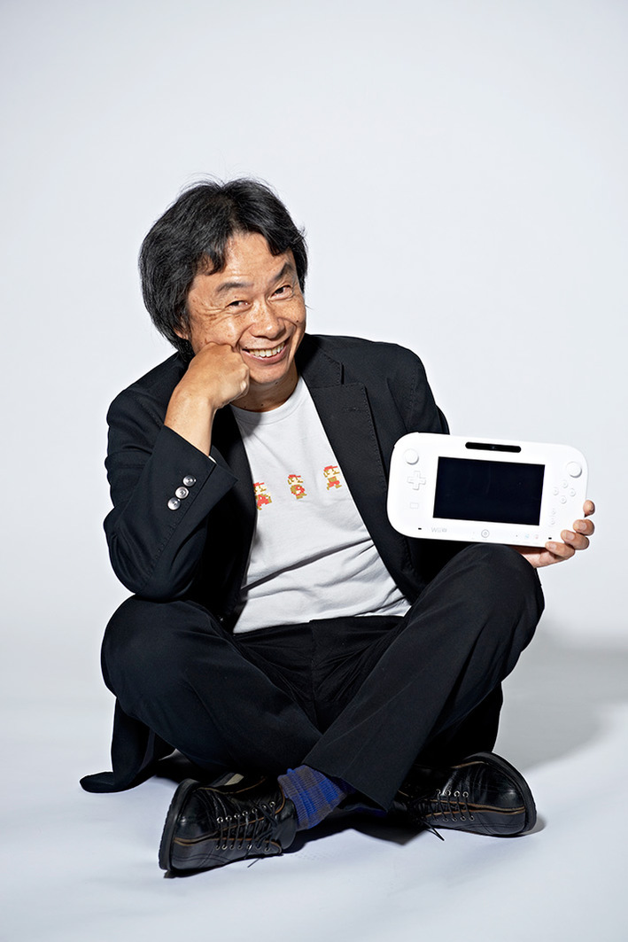 legendary nintendo game designer holding a white Wii U