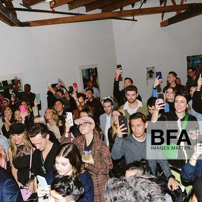 A crowd of people in a gallery exhibition show.