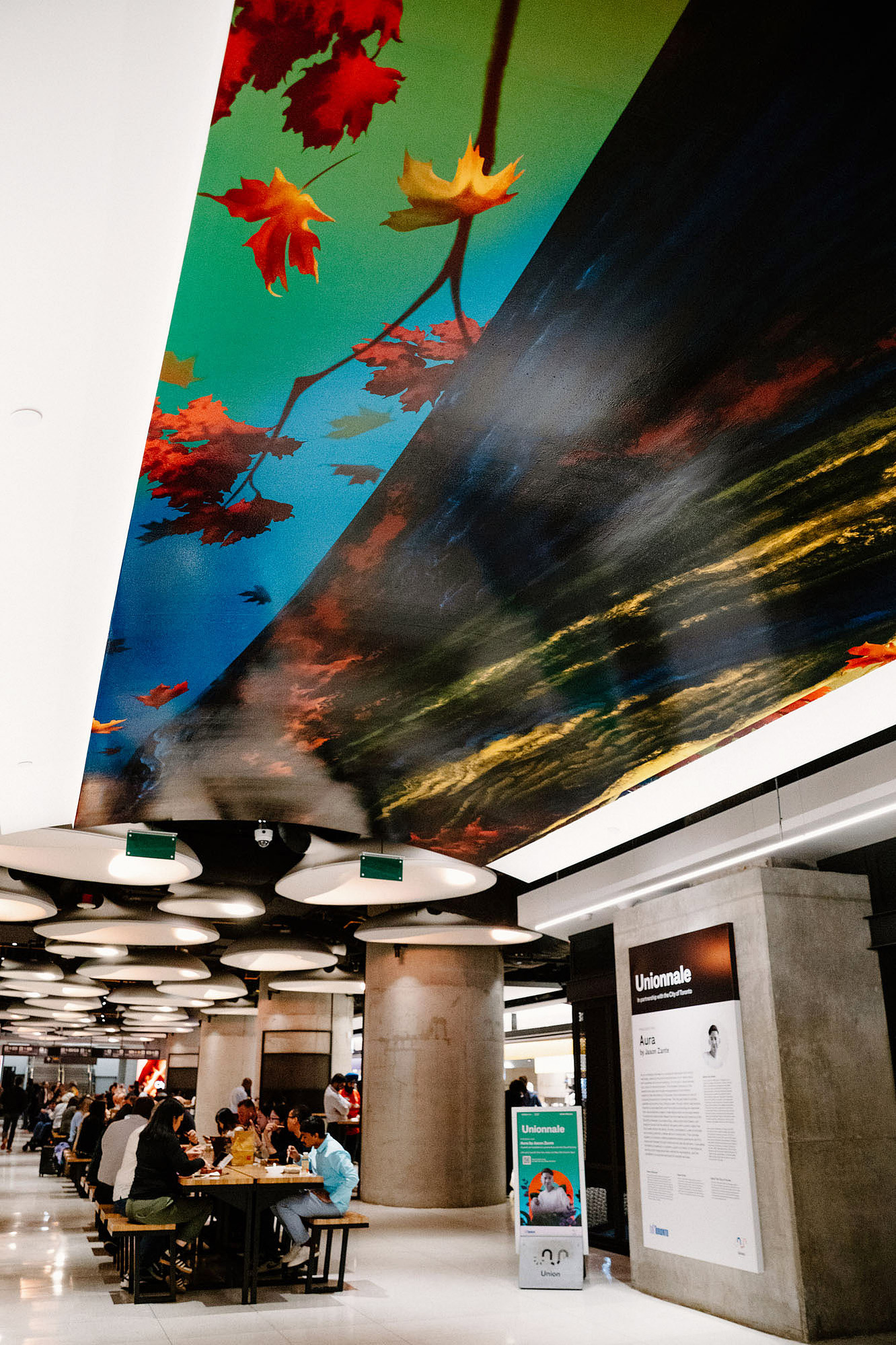 A large tree mural is above a ceiling vault in a public space.