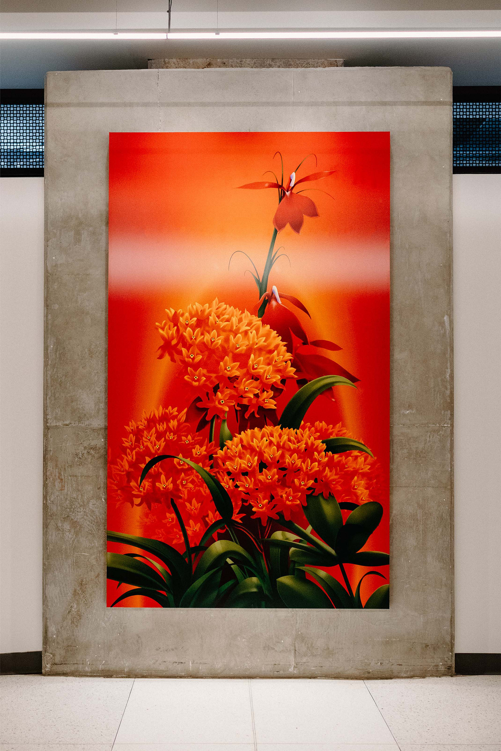 A vibrant red artwork featuring butterfly milkweed and cardinal flowers is displayed on a wall.