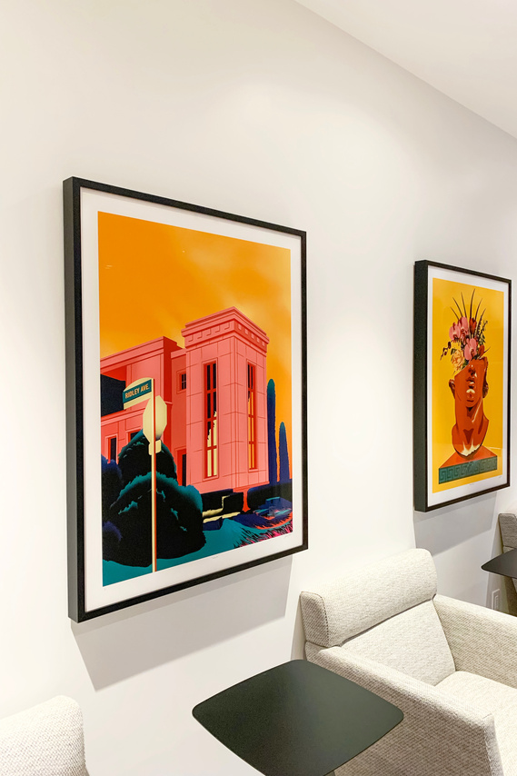 Two framed artwork prints are displayed on a wall inside a modern condominium. 
