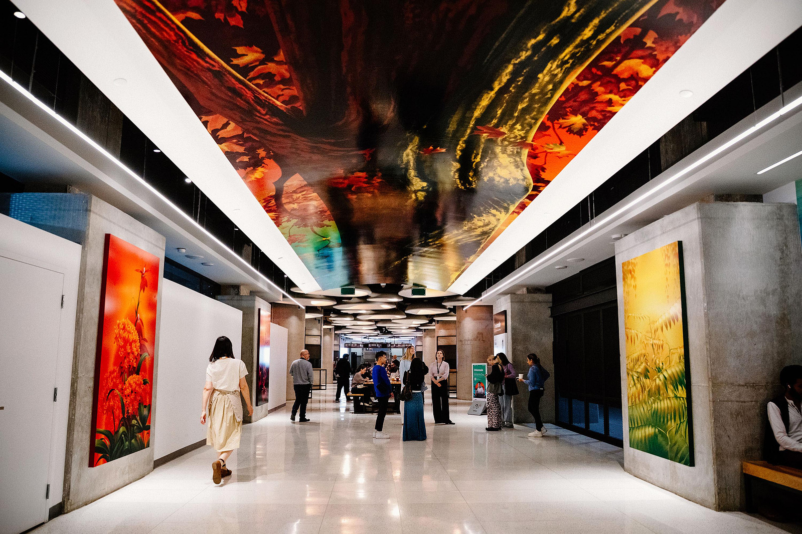 Colourful murals and artworks depicting nature and plants are displayed in a public setting.