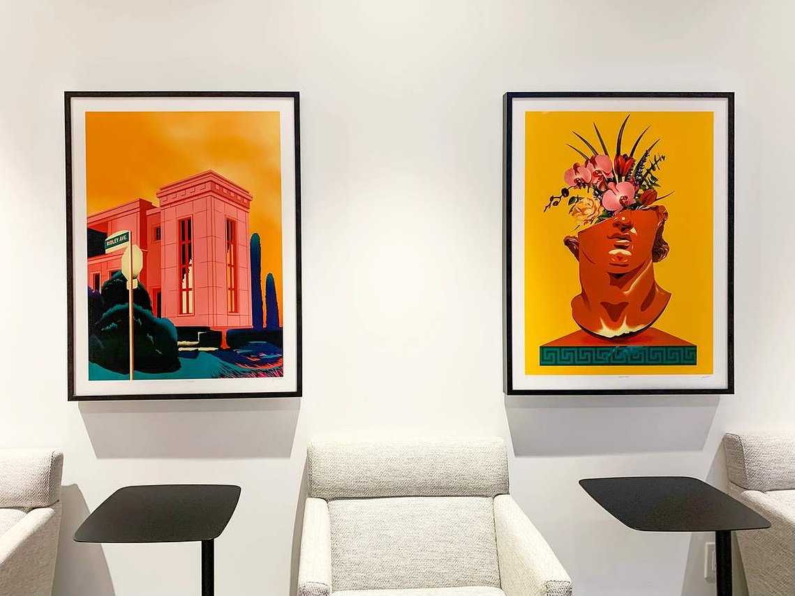 Two framed artwork prints are displayed on a wall inside a modern condominium. 