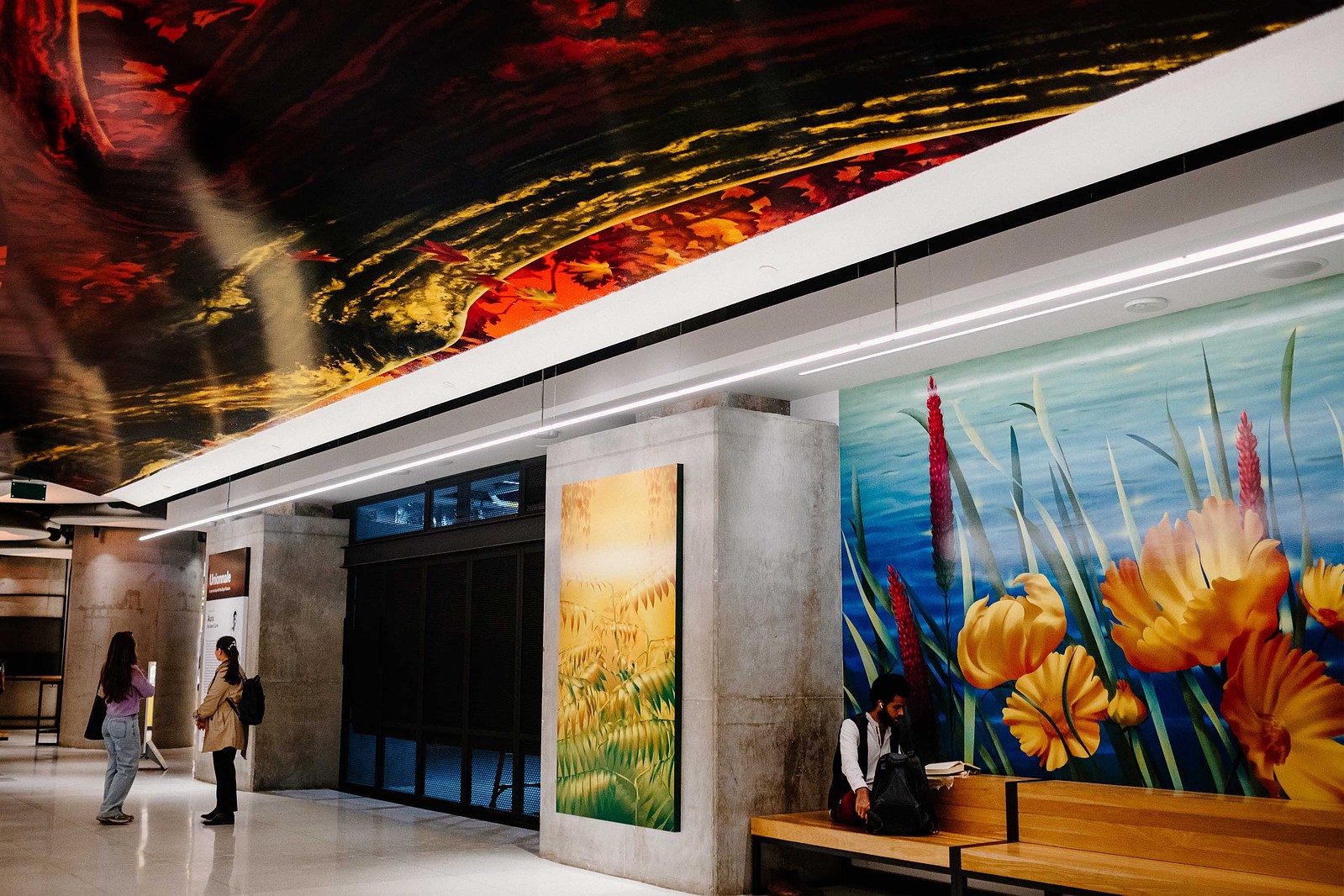 Colourful murals and artworks depicting nature and plants are displayed in a public setting.