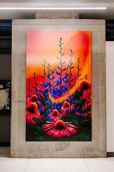 A pink, purple, and red artwork displays flowers and plants on a wall.