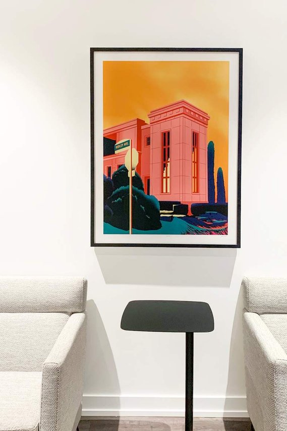 A framed artwork print is displayed on a wall inside a modern condominium. 
