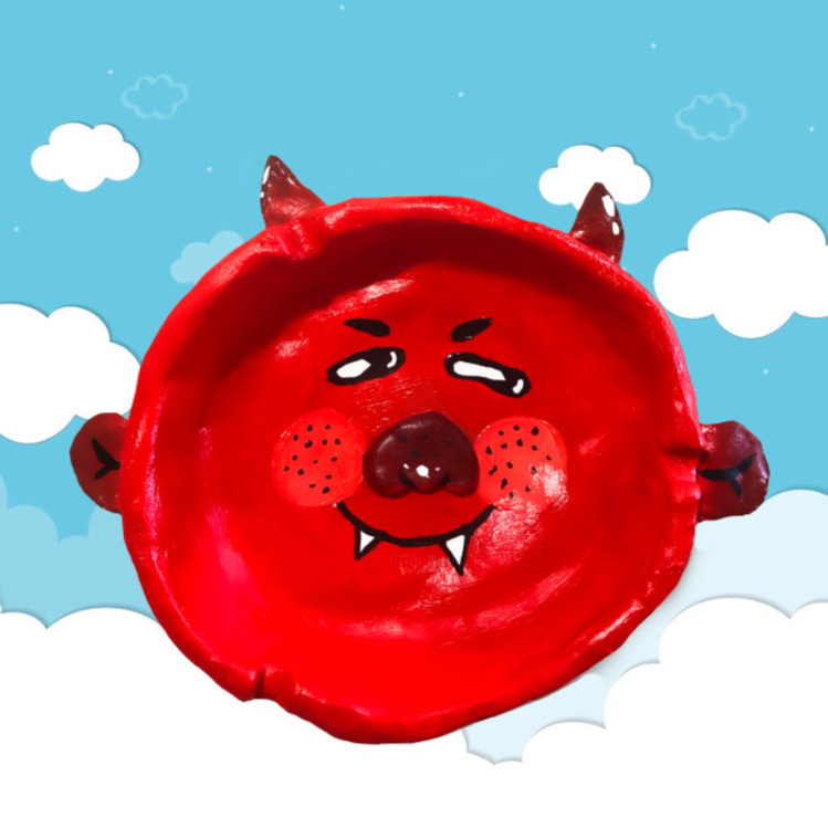 handmade clay ashtray in the shape of a cartoon devil face painted in different shades of red
depicted overtop a background of cartoon clouds