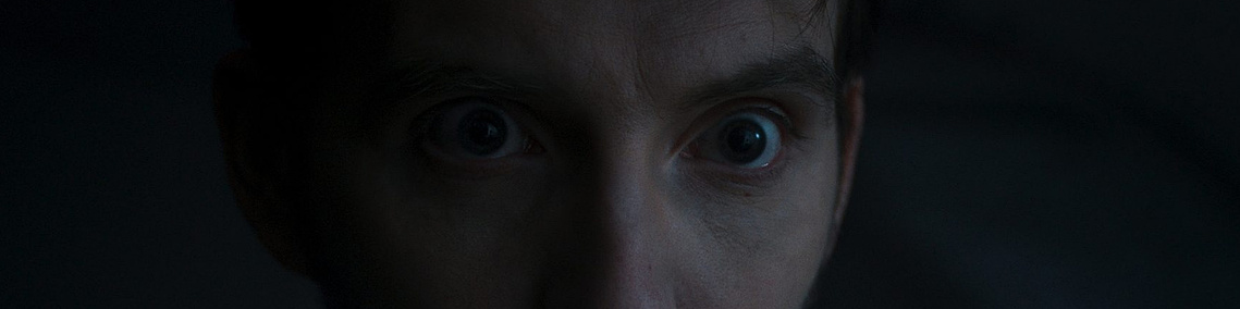 Pierre Cachia close-up, intense gaze, very dark, Mauvais Joueur (2022), dir. Hugo Bréant — cinematography Victor Zyński