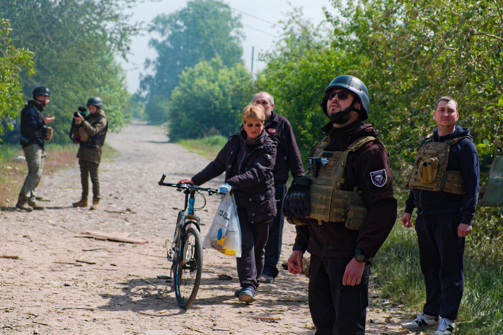 Le policier ukrainien et ces habitants de Vovchansk scrutent le ciel à l'écoute d'un drone russe. Quelques minutes plus tard, un avion a largué deux bombes à environ 500 mètres. 