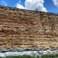 Taken from the drive between San Antonio and Marfa, a tall, layered cliff-like rock that shows layers of sediment.