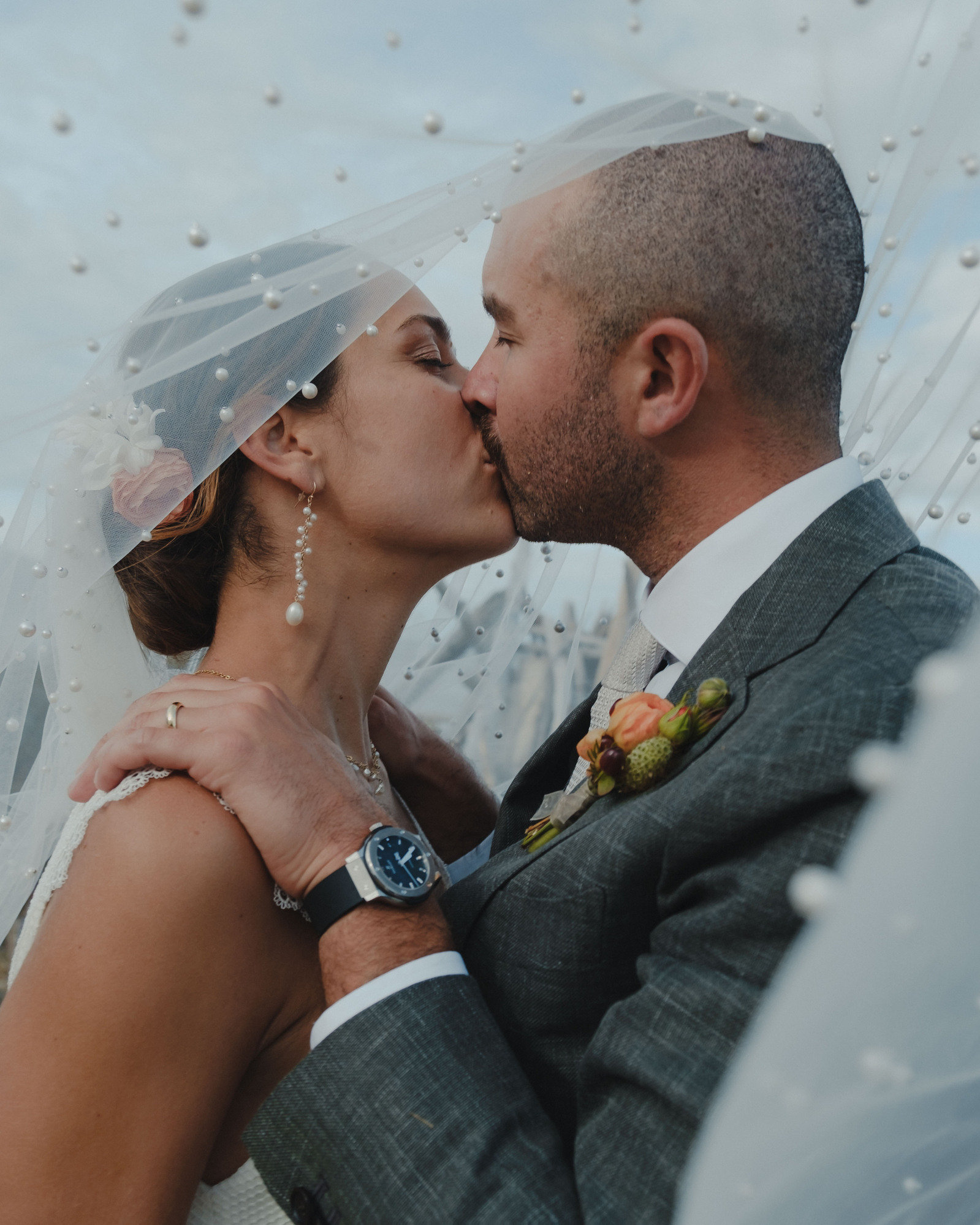A photograph of a couple kissing beneath the veil during their wedding on Guemes Island, Washington